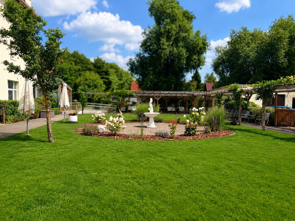 Neugestalteter Garten mit Springbrunnen, Rasenfläche und Pergola